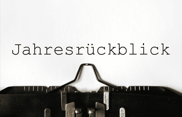 Eine Schreibmaschine im unteren Bildteil, darüber der Schriftzug "Jahresrückblick", der in schwarzer Schrift auf weißem Papier geschrieben steht