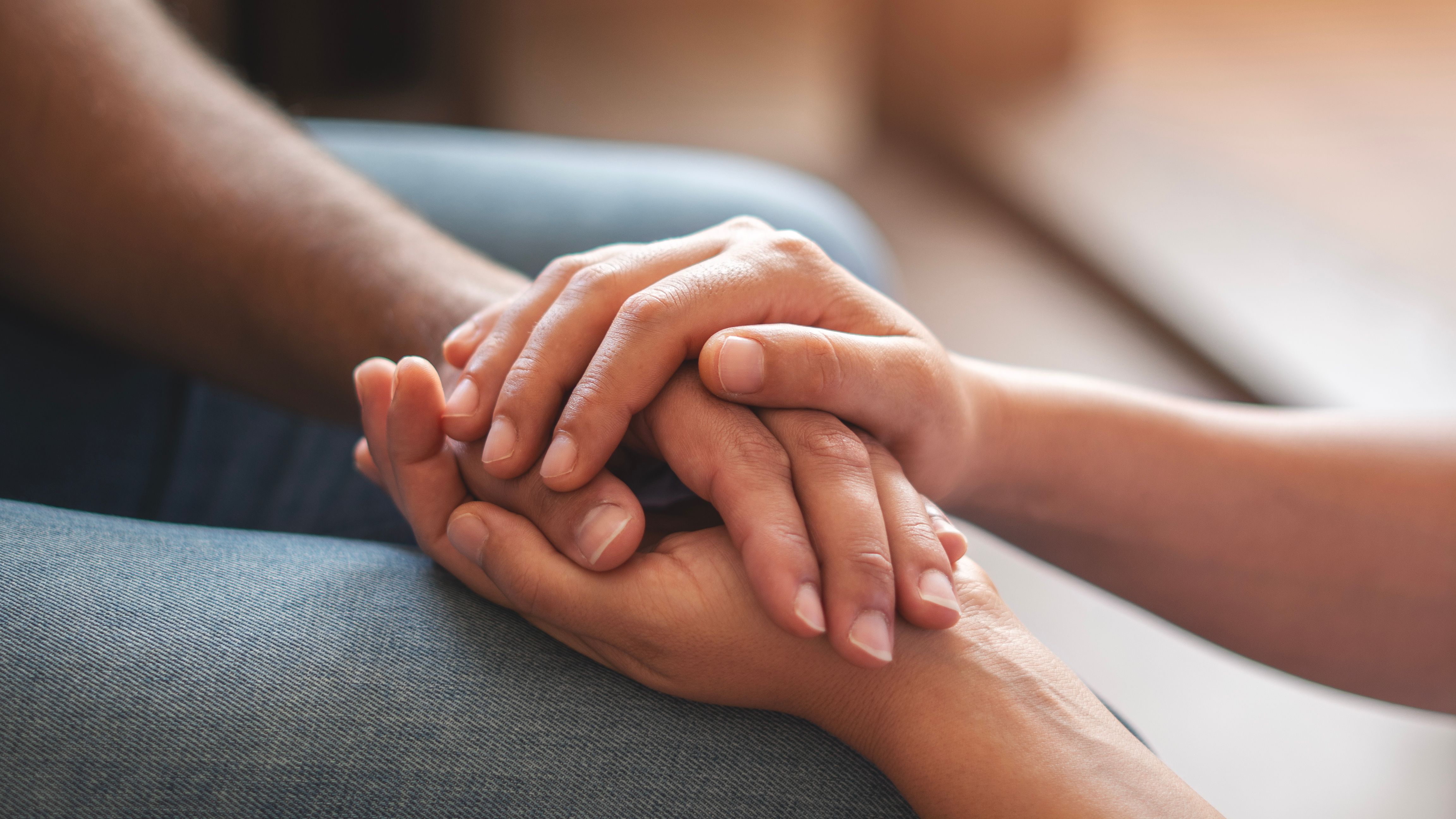 Eine Hand die von zwei anderen Händen umschlossen wird